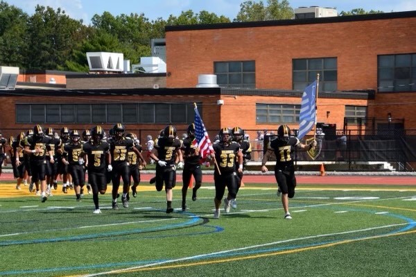 Nanuet's Golden Knights Varsity Football Team runs out onto the field to the roaring sound of the crowd at the start of the Homecoming game.