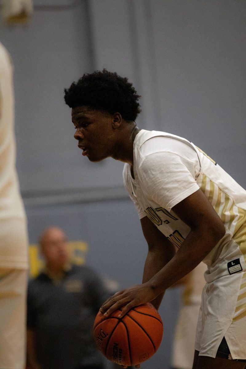 Junior Boris Berthomieux sets his sights on a win at the Boys Basketball game against Obama High School on February 27. 